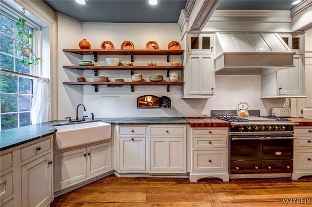 626 Main St, Porter, NY 14174 - kitchen with double oven range, light wood finished floors, custom exhaust hood, recessed lighting, and open shelves