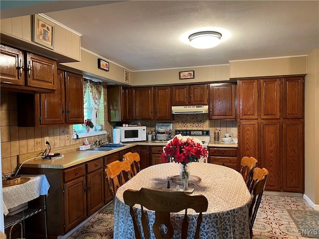 4067 Taylor Rd, Pompey, NY 13078 - kitchen with under cabinet range hood, white appliances, light countertops, backsplash, and crown molding