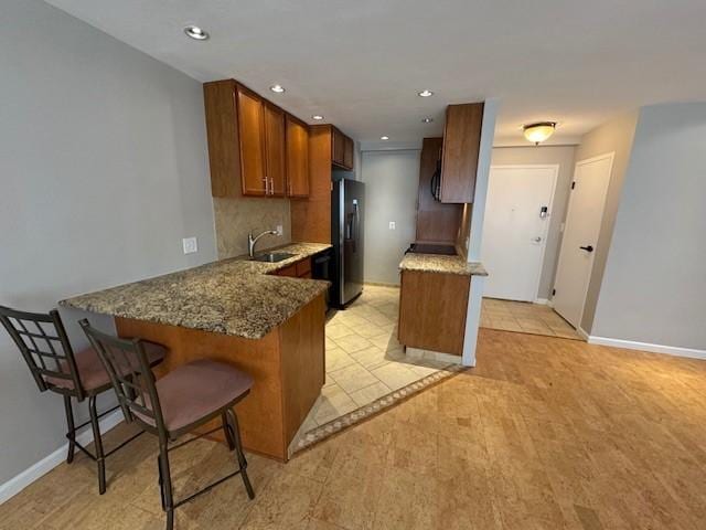 1000 E Ave Unit Un208, Rochester, NY 14607 - kitchen featuring stainless steel refrigerator with ice dispenser, a peninsula, stone counters, and recessed lighting