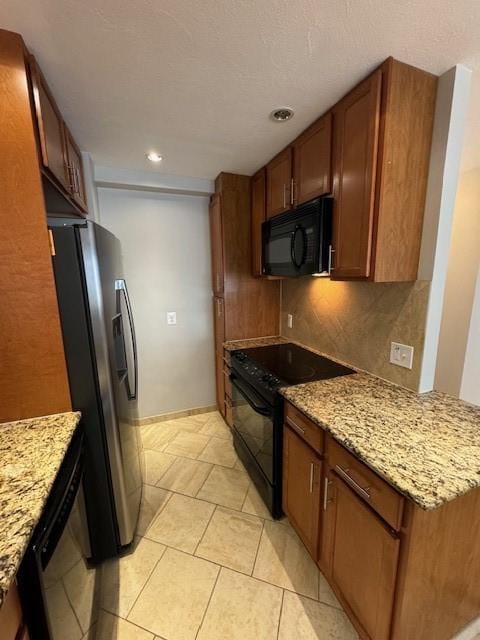 1000 E Ave Unit Un208, Rochester, NY 14607 - kitchen featuring black appliances, brown cabinetry, light stone countertops, recessed lighting, and light tile patterned floors