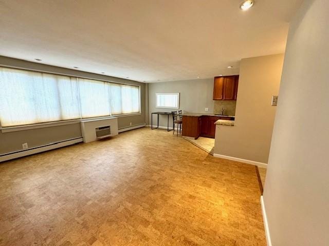 1000 E Ave Unit Un208, Rochester, NY 14607 - unfurnished living room with baseboard heating, recessed lighting, light carpet, and a baseboard radiator
