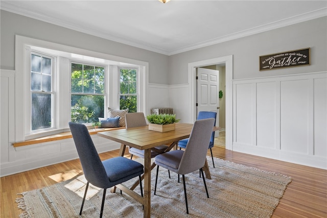 234 Pine Grove Ave, Irondequoit, NY 14617 - dining space featuring a decorative wall, ornamental molding, wainscoting, and light wood-style flooring