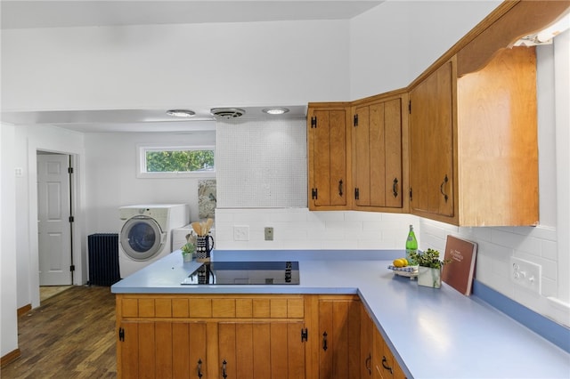 234 Pine Grove Ave, Irondequoit, NY 14617 - kitchen with light countertops, backsplash, brown cabinetry, dark wood finished floors, and washer and dryer
