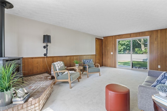 234 Pine Grove Ave, Irondequoit, NY 14617 - living area featuring a wood stove, wooden walls, carpet floors, and a textured ceiling