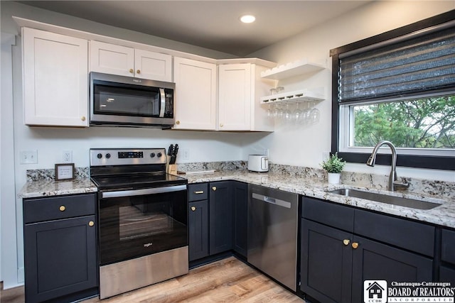 6064 Nys Rte 242 E, Ellicottville, NY 14731 - kitchen featuring appliances with stainless steel finishes, white cabinetry, light stone counters, light wood-style flooring, and open shelves
