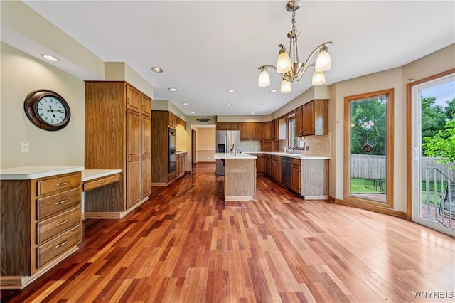 100 Hunt Club Cir, Amherst, NY 14051 - kitchen with dishwasher, light wood-style floors, light countertops, brown cabinets, and recessed lighting