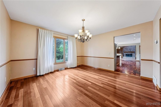 100 Hunt Club Cir, Amherst, NY 14051 - empty room with a chandelier, hardwood / wood-style floors, and a large fireplace