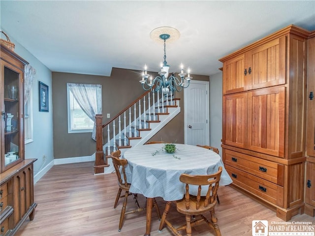 6295 Stockton Hartfield Rd, Chautauqua, NY 14728 - dining area featuring a chandelier, stairway, and light wood-style flooring