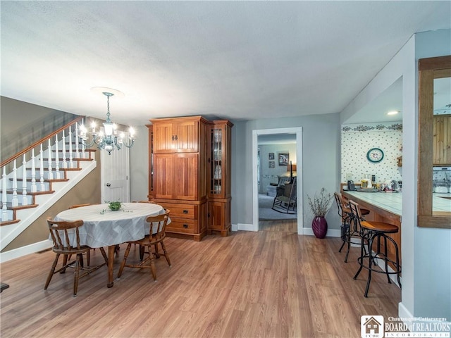 6295 Stockton Hartfield Rd, Chautauqua, NY 14728 - dining area with a chandelier, light wood-style floors, and stairs