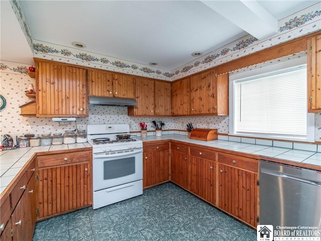 6295 Stockton Hartfield Rd, Chautauqua, NY 14728 - kitchen with white gas range, dishwasher, tile countertops, and under cabinet range hood