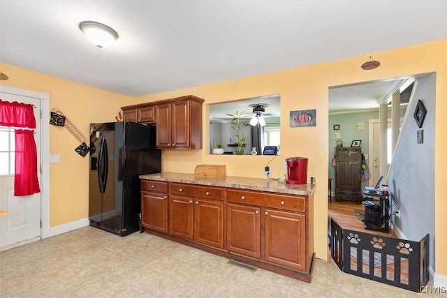 213 Roxann Ave, Cicero, NY 13212 - kitchen with black fridge with ice dispenser, healthy amount of natural light, brown cabinetry, and light floors