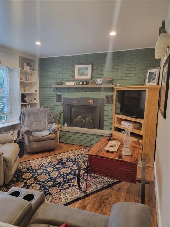 244 State Highway 320, Norwich, NY 13815 - living room with wood finished floors, a fireplace, and brick wall