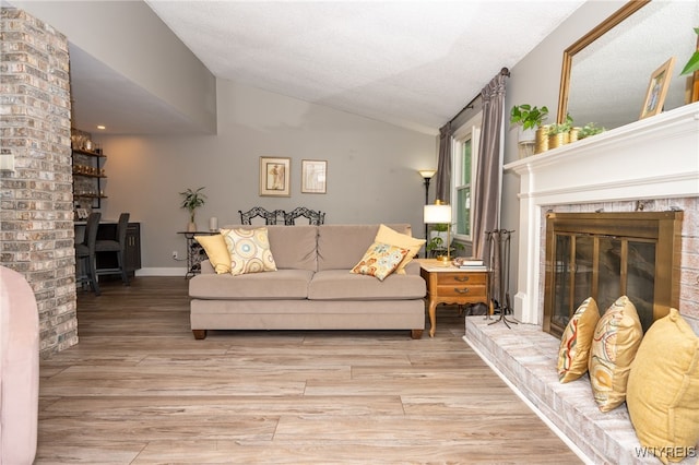 253 Old Oak Post Rd, Amherst, NY 14051 - living room featuring vaulted ceiling, light wood-style floors, a fireplace, and a wood stove