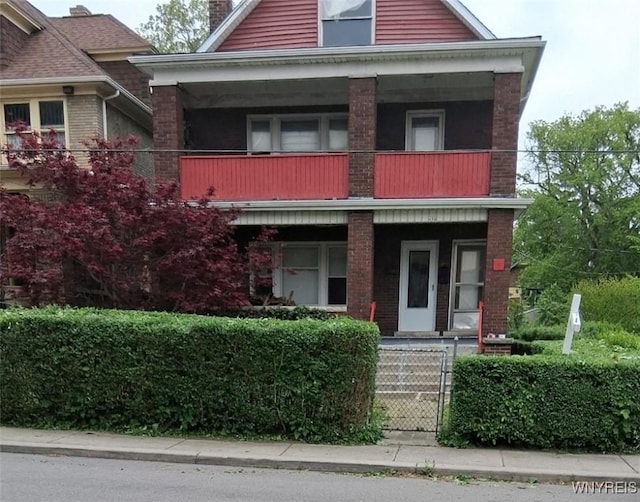 425 12th St, Niagara Falls, NY 14303 - view of front of property featuring a balcony, a porch, a chimney, and brick siding