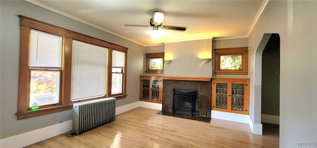 425 12th St, Niagara Falls, NY 14303 - unfurnished living room featuring radiator, a fireplace, wood finished floors, a ceiling fan, and ornamental molding
