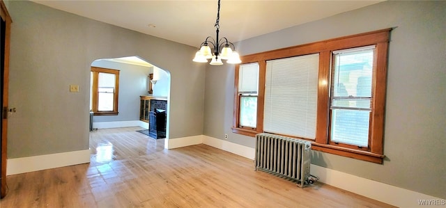 425 12th St, Niagara Falls, NY 14303 - unfurnished dining area with radiator heating unit, arched walkways, plenty of natural light, and wood finished floors