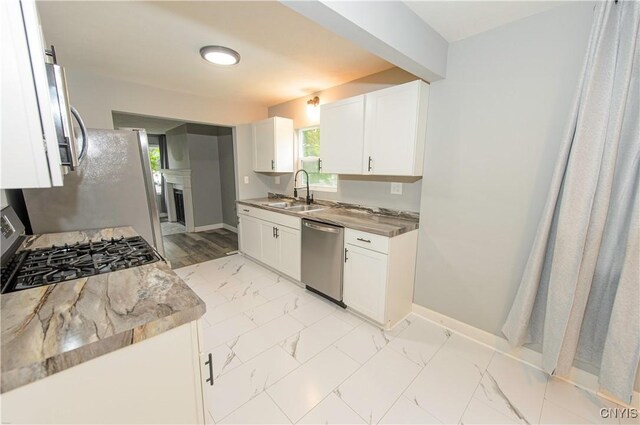 118 Hanover Ave, Salina, NY 13088 - kitchen with appliances with stainless steel finishes, light marble finish flooring, a fireplace, and white cabinets