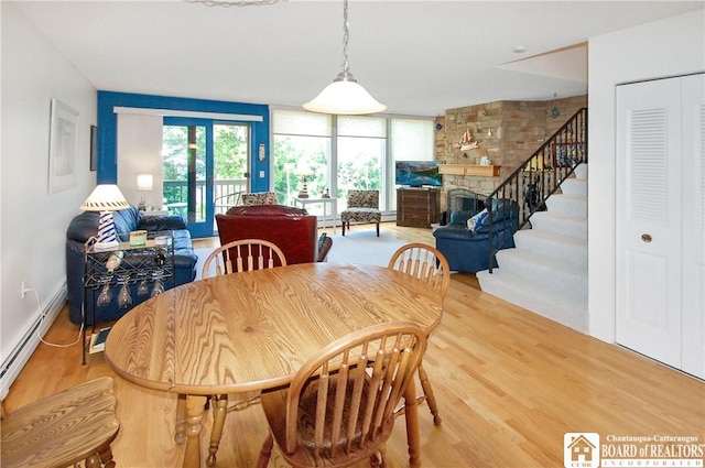 C4 Oneida Dr, Chautauqua, NY 14728 - dining space featuring light wood-style floors, stairs, a fireplace, and baseboard heating