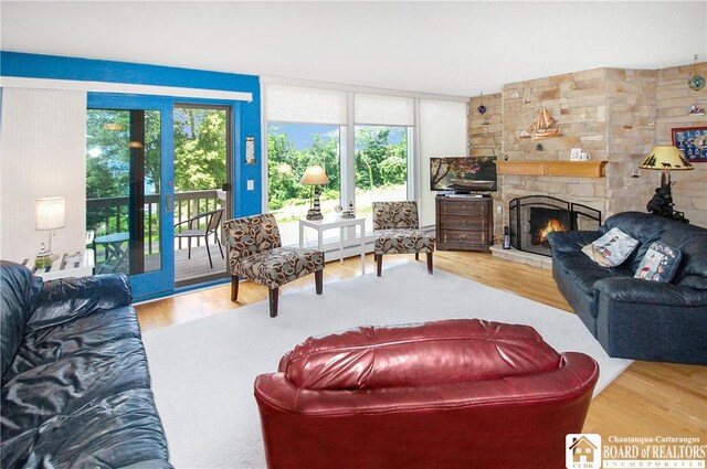 C4 Oneida Dr, Chautauqua, NY 14728 - living area with a stone fireplace, wood finished floors, and baseboard heating