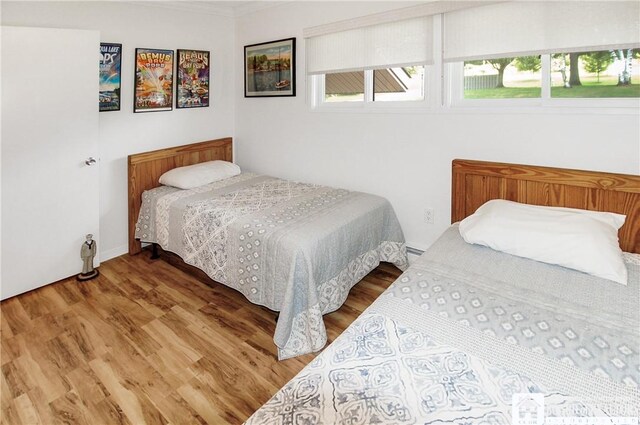 C4 Oneida Dr, Chautauqua, NY 14728 - bedroom with wood finished floors, multiple windows, a baseboard heating unit, and crown molding