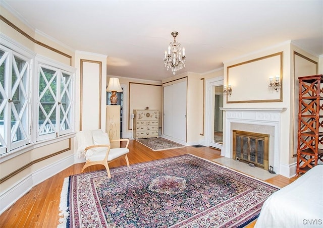 4790 E Lake Rd, Cazenovia, NY 13035 - living room with wood finished floors, a chandelier, a fireplace with flush hearth, and ornamental molding