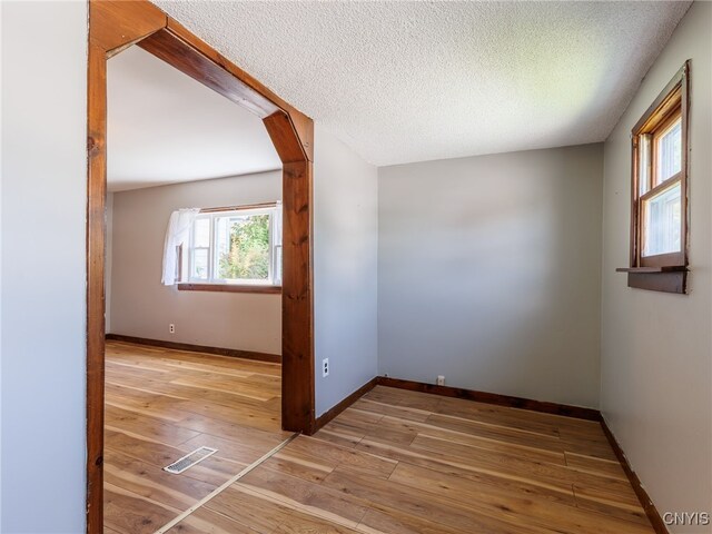 308 Howk St, Watertown City, NY 13601 - spare room with a textured ceiling, hardwood / wood-style floors, and arched walkways
