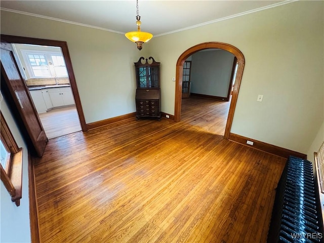 39 Chestnut St, Persia, NY 14070 - empty room featuring wood-type flooring, arched walkways, and crown molding
