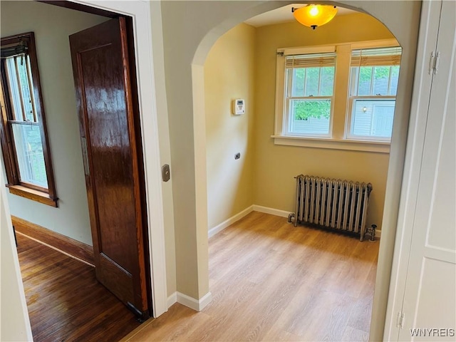 39 Chestnut St, Persia, NY 14070 - hall with radiator heating unit, arched walkways, and wood finished floors