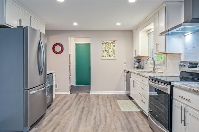 3389 Orchid Cres, Walworth, NY 14568 - kitchen featuring appliances with stainless steel finishes, wall chimney range hood, recessed lighting, light wood finished floors, and white cabinets