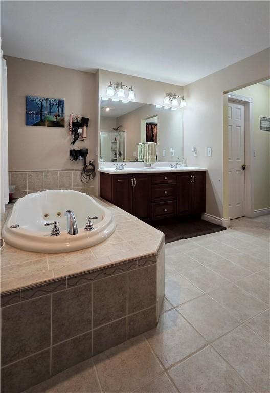 3390 Conhocton Rd, Erwin, NY 14870 - full bath with double vanity, a jetted tub, and tile patterned flooring