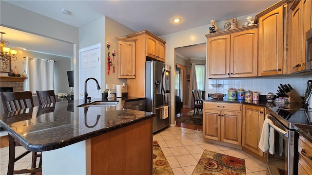 3390 Conhocton Rd, Erwin, NY 14870 - kitchen with appliances with stainless steel finishes, a peninsula, a breakfast bar area, light tile patterned floors, and dark stone countertops