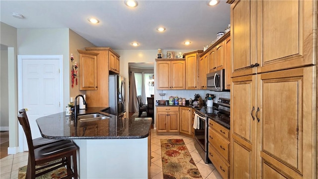 3390 Conhocton Rd, Erwin, NY 14870 - kitchen with stainless steel appliances, light tile patterned flooring, a breakfast bar area, dark stone countertops, and a peninsula