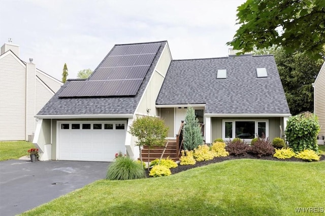 89 Rambling Rd, Amherst, NY 14051 - view of front of home with an attached garage, roof mounted solar panels, a front yard, driveway, and roof with shingles