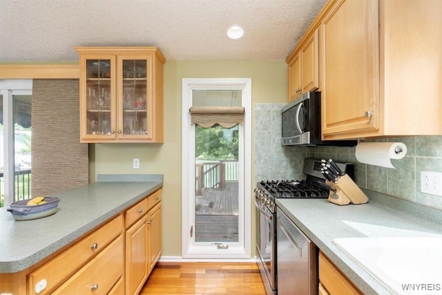89 Rambling Rd, Amherst, NY 14051 - kitchen featuring stainless steel appliances, a textured ceiling, light brown cabinetry, healthy amount of natural light, and light wood-type flooring