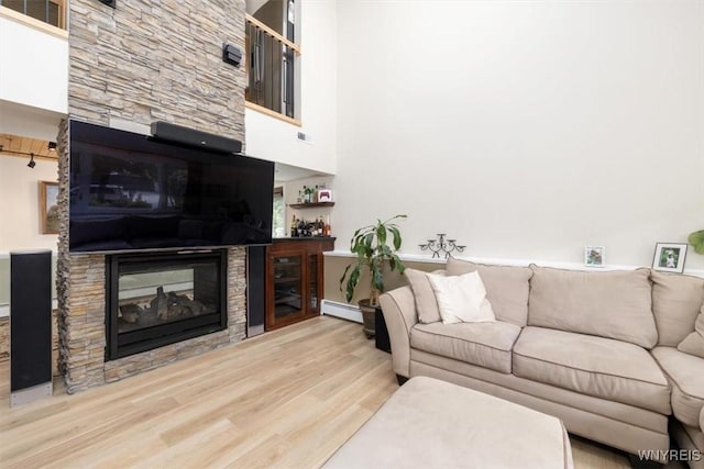89 Rambling Rd, Amherst, NY 14051 - living room with a multi sided fireplace, wood finished floors, a baseboard radiator, and a high ceiling
