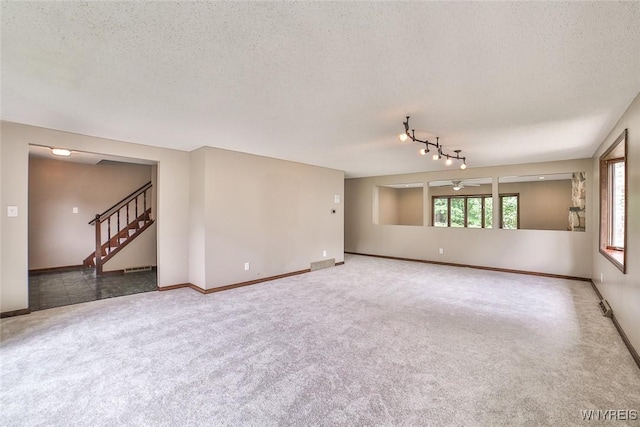 210 Townline Rd, Elma, NY 14059 - unfurnished room with ceiling fan, carpet floors, a textured ceiling, stairs, and rail lighting