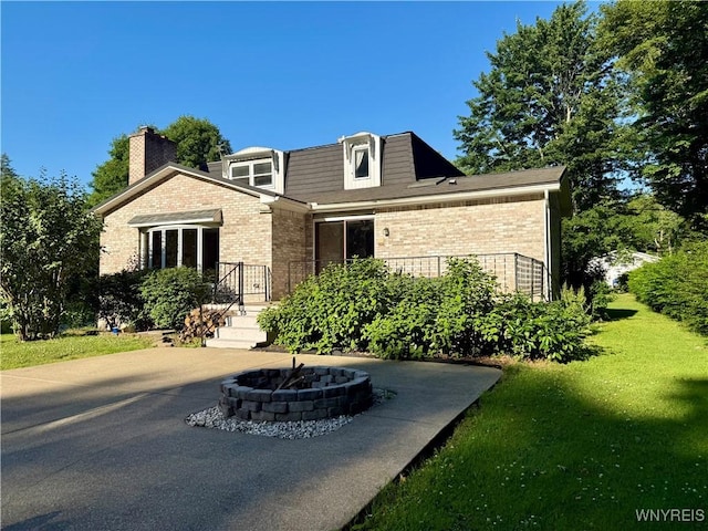 210 Townline Rd, Elma, NY 14059 - view of front facade with brick siding, a fire pit, a front lawn, and a chimney