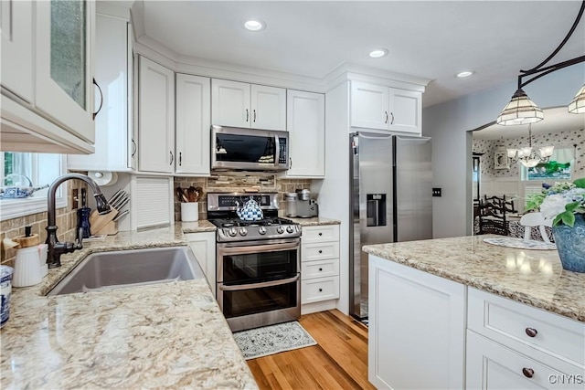 5 Family Cir, Lee, NY 13363 - kitchen with appliances with stainless steel finishes, white cabinetry, decorative backsplash, light wood-style flooring, and a chandelier