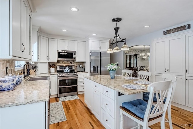 5 Family Cir, Lee, NY 13363 - kitchen with stainless steel appliances, a chandelier, a kitchen bar, white cabinetry, and light stone countertops