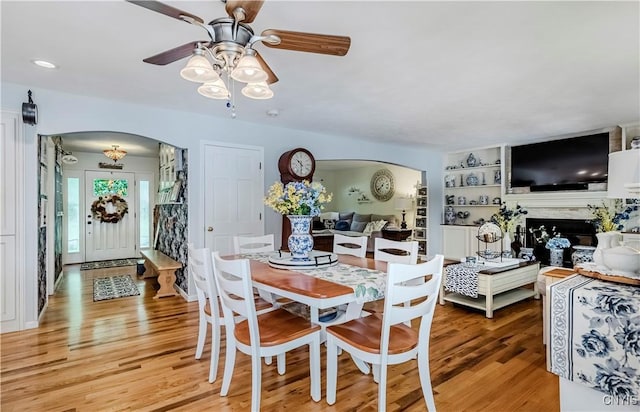 5 Family Cir, Lee, NY 13363 - dining area featuring arched walkways, a ceiling fan, light wood-style floors, and a fireplace