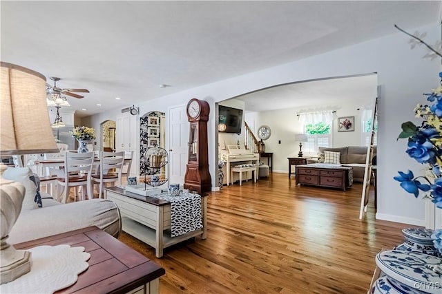 5 Family Cir, Lee, NY 13363 - living area featuring arched walkways, wood finished floors, stairway, and ceiling fan
