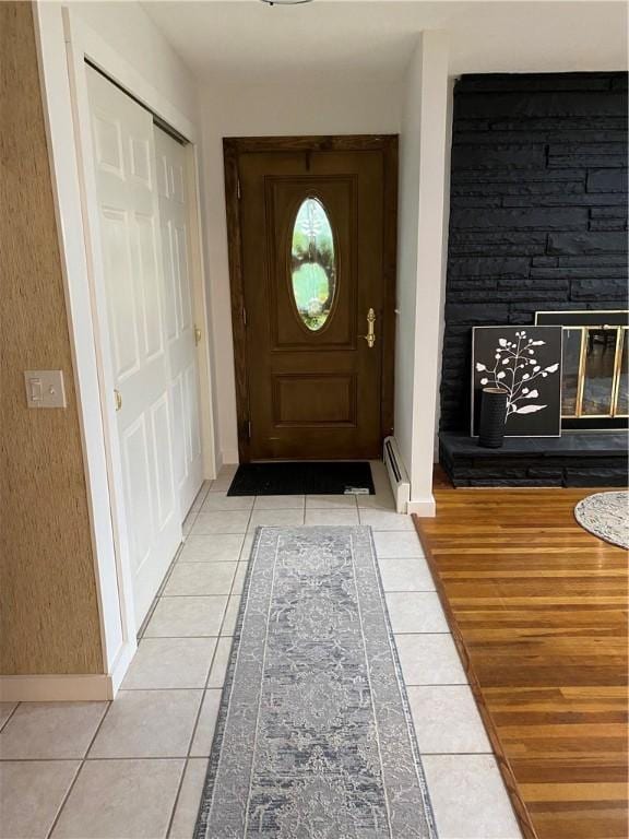 2115 Hornby Rd, Orange, NY 14812 - entrance foyer with light tile patterned flooring, a glass covered fireplace, and a baseboard radiator