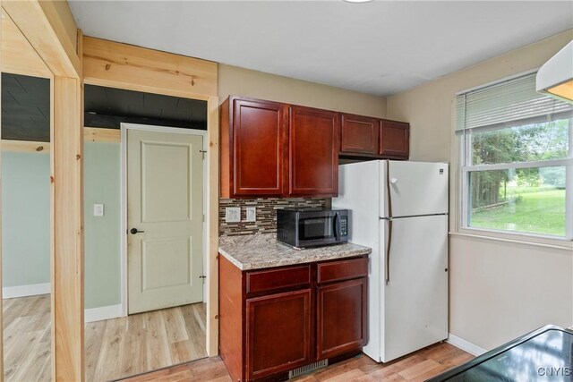 2129 Berry Rd, Lafayette, NY 13084 - kitchen with black microwave, freestanding refrigerator, light wood-style floors, dark brown cabinets, and decorative backsplash