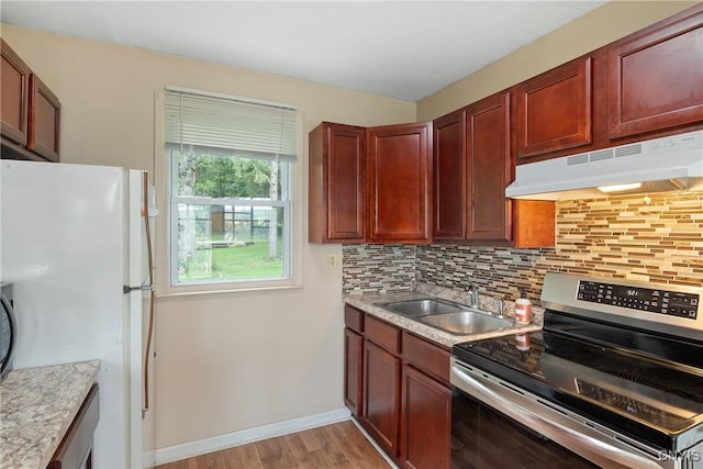 2129 Berry Rd, Lafayette, NY 13084 - kitchen with stainless steel electric range, under cabinet range hood, freestanding refrigerator, tasteful backsplash, and light wood-style floors