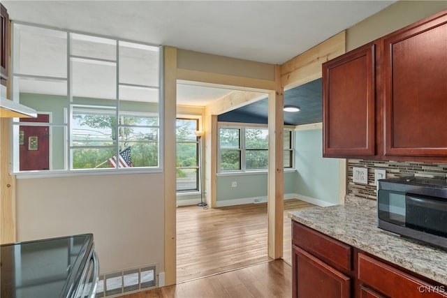2129 Berry Rd, Lafayette, NY 13084 - kitchen featuring black microwave, wood finished floors, electric stove, backsplash, and light stone countertops