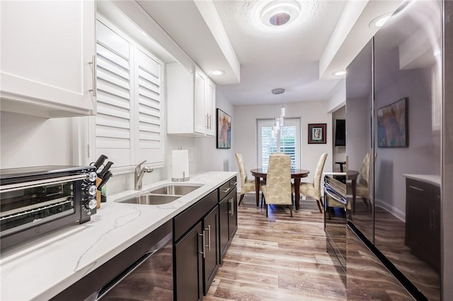 42 Wood Creek Dr, Pittsford, NY 14534 - kitchen with white cabinets, light stone counters, hanging light fixtures, light wood-style floors, and recessed lighting