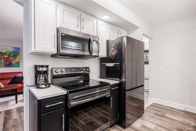42 Wood Creek Dr, Pittsford, NY 14534 - kitchen with stainless steel appliances, white cabinets, light countertops, and light wood-type flooring