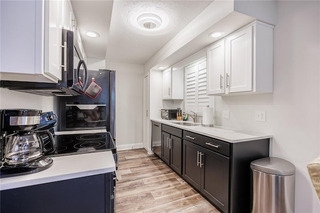 42 Wood Creek Dr, Pittsford, NY 14534 - kitchen with light countertops, appliances with stainless steel finishes, light wood finished floors, white cabinets, and recessed lighting