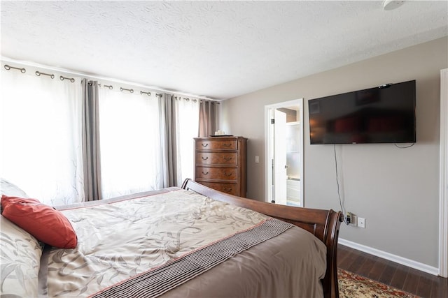 255 Watson Rd, Perinton, NY 14450 - bedroom featuring dark wood-style flooring, connected bathroom, and a textured ceiling