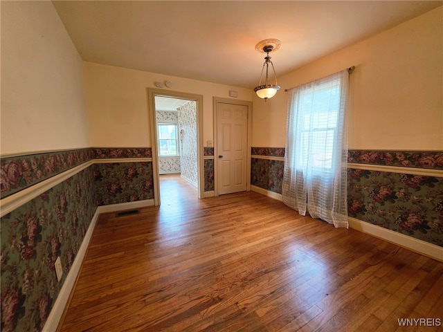 942 N 4th St, Olean, NY 14760 - unfurnished dining area with wainscoting, wallpapered walls, and wood finished floors